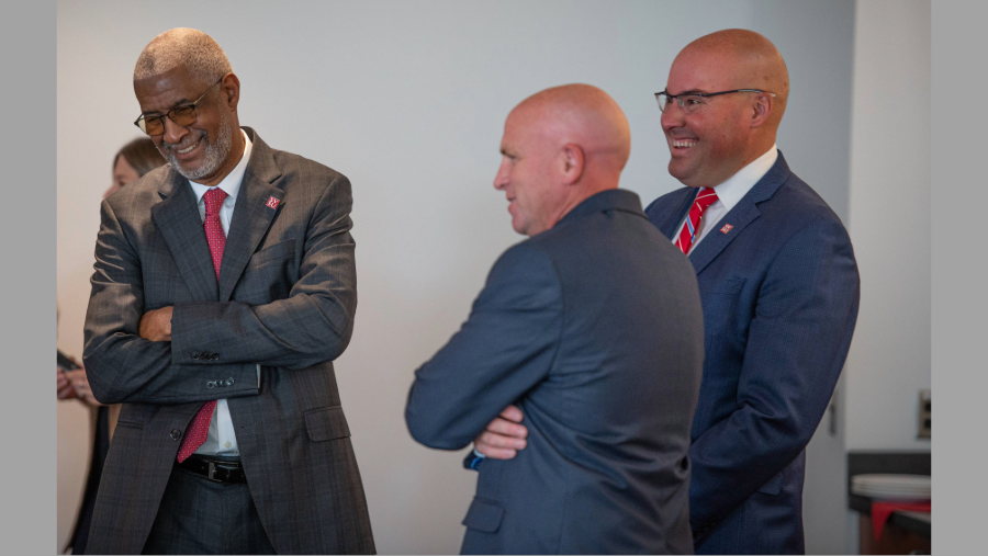 three men in suits sharing a laugh